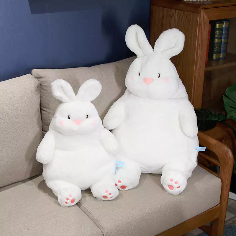 two white fat rabbits stuffed dolls sat on the sofa